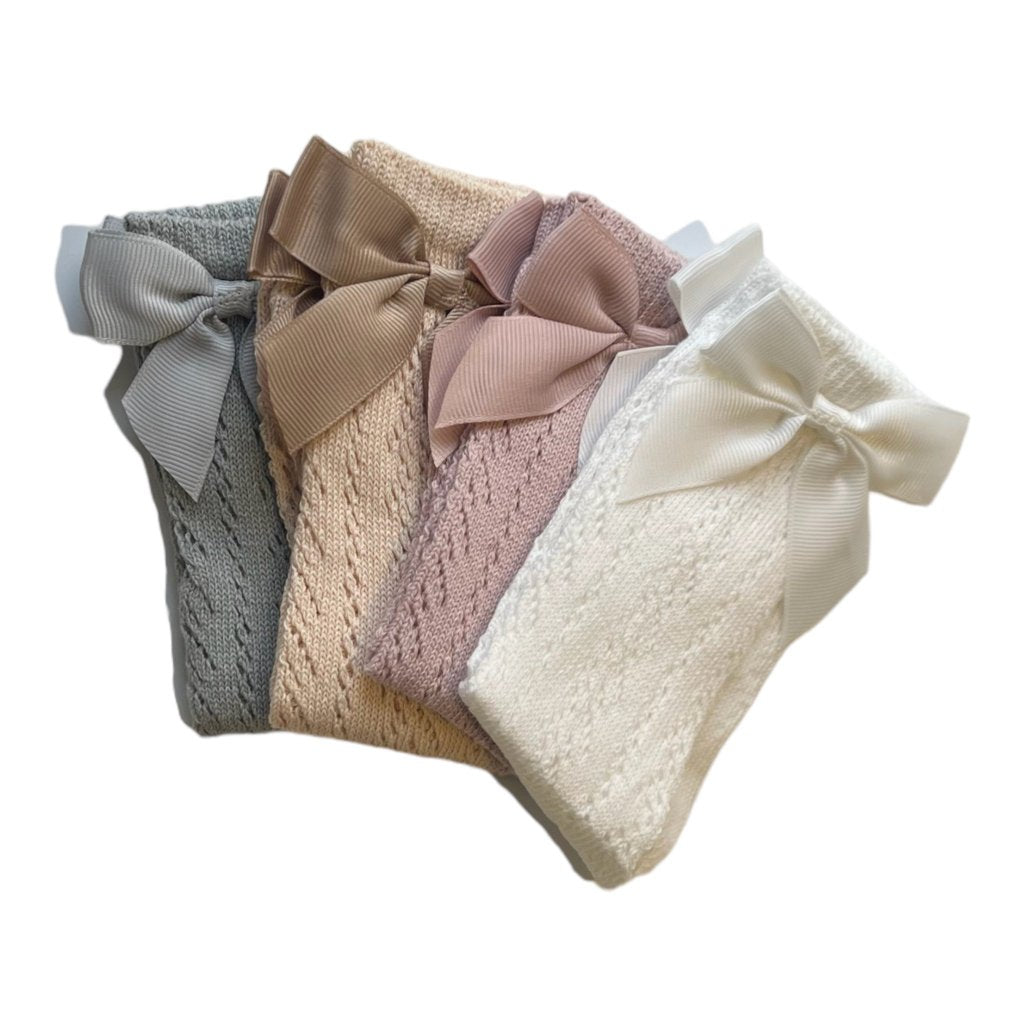 Intricate pointelle knit detail on soft high socks, perfect for baby and toddler outfits.